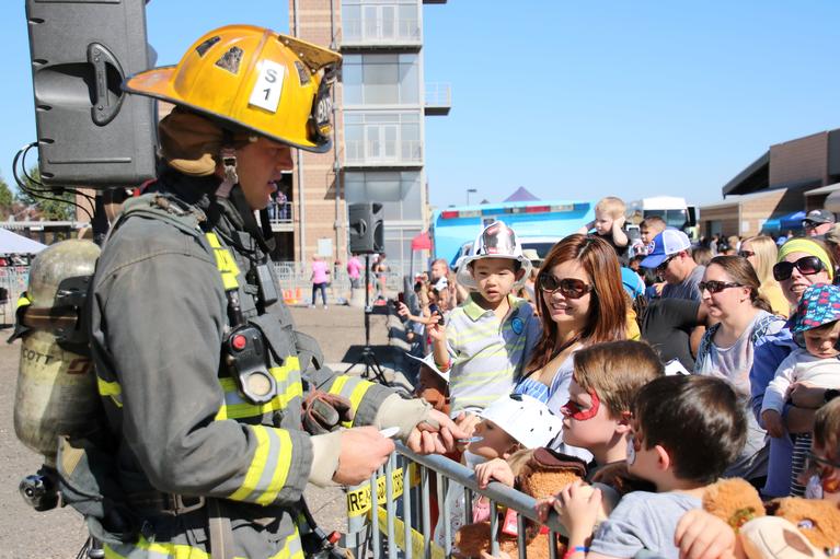 Firefighter in gear meeting children